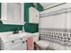 Well-maintained bathroom with vanity, medicine cabinet, and a shower featuring patterned curtain at 16160 W Custer Ln, Surprise, AZ 85379