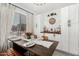 Bright dining area features a wooden table set for a meal, white cabinetry, and a curated bar area at 16160 W Custer Ln, Surprise, AZ 85379