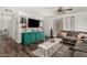 Stylish living room featuring wood flooring, a large TV console, and comfortable seating at 16160 W Custer Ln, Surprise, AZ 85379