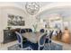 Elegant dining room featuring a rustic wood table, stylish chandelier, and views of the bright, modern kitchen at 1771 E Alegria Rd, Queen Creek, AZ 85140