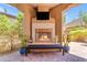 Inviting covered patio featuring a cozy fireplace, comfortable bench seating, and stylish desert landscaping at 1771 E Alegria Rd, Queen Creek, AZ 85140