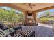 Inviting outdoor patio with a stone fireplace, comfortable seating, and lush desert landscaping at 1771 E Alegria Rd, Queen Creek, AZ 85140