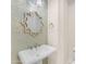 Stylish powder room with a pedestal sink, decorative mirror, and chic mosaic tile accent wall at 1771 E Alegria Rd, Queen Creek, AZ 85140