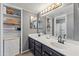 Bathroom with double sinks, dark cabinets, and a built-in shelving unit for storage at 1800 W Elliot Rd # 240, Chandler, AZ 85224