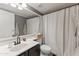 Well-lit bathroom with a shower featuring a shower curtain and ample counter space at 1800 W Elliot Rd # 240, Chandler, AZ 85224