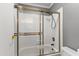 Bathroom featuring a shower with glass doors and a white tile surround at 1800 W Elliot Rd # 240, Chandler, AZ 85224