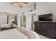 Spacious bedroom with mirrored closet doors, a dark wood dresser, and an arched doorway at 1800 W Elliot Rd # 240, Chandler, AZ 85224