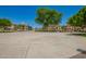 Outdoor basketball court with well-maintained surface surrounded by trees and neighborhood homes for recreational fun at 1836 N 77Th Gln, Phoenix, AZ 85035