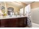 Bright bathroom features a dual sink vanity and a shower-tub combo with decorative curtain at 1836 N 77Th Gln, Phoenix, AZ 85035