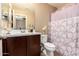 Cozy bathroom offering a single sink vanity and a toilet with a decorative curtain at 1836 N 77Th Gln, Phoenix, AZ 85035