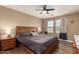Comfortable bedroom featuring a ceiling fan, wood flooring, and a light-filled window at 1836 N 77Th Gln, Phoenix, AZ 85035
