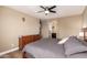 This bedroom has wood flooring, a ceiling fan, and an adjacent bathroom at 1836 N 77Th Gln, Phoenix, AZ 85035