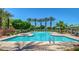 Resort-style community pool with fountains and lounging areas, surrounded by lush landscaping and palm trees at 1836 N 77Th Gln, Phoenix, AZ 85035