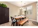 Bright dining room with a wooden table, bench seating, and a modern light fixture at 1836 N 77Th Gln, Phoenix, AZ 85035