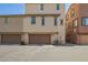 Tan home featuring dual garage doors and back alley access at 1836 N 77Th Gln, Phoenix, AZ 85035