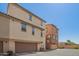 Tan home featuring dual garage doors and back alley access at 1836 N 77Th Gln, Phoenix, AZ 85035