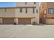 Tan home featuring dual garage doors and back alley access at 1836 N 77Th Gln, Phoenix, AZ 85035