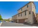 Back exterior view of tan home, featuring dual garage doors, with an alley at 1836 N 77Th Gln, Phoenix, AZ 85035