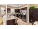 Well-equipped kitchen with stainless steel appliances, granite countertops, and dark wood cabinets at 1836 N 77Th Gln, Phoenix, AZ 85035