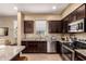 Modern kitchen with stainless steel appliances, granite countertops and dark wood cabinetry at 1836 N 77Th Gln, Phoenix, AZ 85035