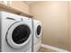 Functional laundry room with a front loading washer and dryer and upper shelf for supplies at 1836 N 77Th Gln, Phoenix, AZ 85035