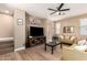 Bright living room featuring wood floors, a ceiling fan, and a modern entertainment center at 1836 N 77Th Gln, Phoenix, AZ 85035