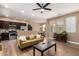 Open-concept living room with modern furniture, a ceiling fan, and wood floors at 1836 N 77Th Gln, Phoenix, AZ 85035