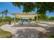 Shaded picnic pavilion with tables perfect for outdoor dining, with playground visible in background at 1836 N 77Th Gln, Phoenix, AZ 85035