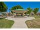 Covered picnic area for Gathering gatherings near homes with tables and seating amidst landscaped grounds at 1836 N 77Th Gln, Phoenix, AZ 85035