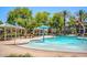 A beautifully landscaped community pool boasts splash features, shaded cabanas, and comfortable seating areas at 1836 N 77Th Gln, Phoenix, AZ 85035