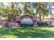 A welcoming stone community sign adorned with vibrant flower planters and lush green landscaping at 1836 N 77Th Gln, Phoenix, AZ 85035