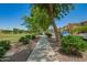 Tree-lined sidewalk runs next to homes and a grassy park, perfect for a walk and enjoying the outdoors at 1836 N 77Th Gln, Phoenix, AZ 85035
