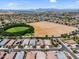Aerial view of a residential area featuring many homes and a large empty lot at 21352 E Domingo Rd, Queen Creek, AZ 85142