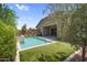 Spacious backyard showcasing a sparkling pool, lush landscaping, and covered patio, perfect for outdoor living at 21352 E Domingo Rd, Queen Creek, AZ 85142