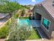 Relaxing backyard oasis features a sparkling pool, covered patio, and lush landscaping at 21352 E Domingo Rd, Queen Creek, AZ 85142