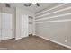 Spacious bedroom with modern striped accent wall, and a closet with sliding doors at 21352 E Domingo Rd, Queen Creek, AZ 85142