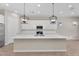 Bright kitchen with modern pendant lighting, stainless steel appliances, and a spacious island with seating at 21352 E Domingo Rd, Queen Creek, AZ 85142