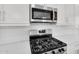 Close-up view of modern stainless steel microwave and gas range, set against a white subway tile backsplash at 21352 E Domingo Rd, Queen Creek, AZ 85142