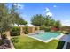 Backyard pool with water feature, framed by artificial turf, mature landscaping, and privacy walls at 21352 E Domingo Rd, Queen Creek, AZ 85142