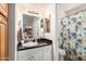 Bathroom with black countertops, white vanity, decorative shower curtain, and good lighting at 2228 N 52Nd St # 140, Phoenix, AZ 85008