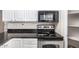 Close-up of kitchen appliances: electric range with stainless steel trim and black microwave at 2228 N 52Nd St # 140, Phoenix, AZ 85008