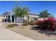 A new home showing the side and front yard, landscaped with flowering bushes and small trees at 22669 E Saddle Way, Queen Creek, AZ 85142