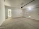 Spacious, unfinished two-car garage with white walls, concrete floor, and two access doors at 22669 E Saddle Way, Queen Creek, AZ 85142