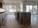 Spacious kitchen with island, brown cabinetry, and modern lighting fixtures at 22669 E Saddle Way, Queen Creek, AZ 85142
