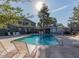 Community pool with lounge chairs, tall shade trees, pool house, and other community buildings at 2301 E University Dr # 269, Mesa, AZ 85213