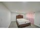 Neutral bedroom showcases a sleek platform bed frame with a light-colored carpet and privacy drapes at 2430 W Papago St, Phoenix, AZ 85009