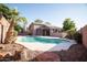 Relaxing backyard features a sparkling pool, landscaping, and a covered patio at 2533 N 114Th Ave, Avondale, AZ 85392