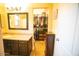 Bathroom with vanity and a mirror with a view of the walk-in closet with clothes hanging at 2533 N 114Th Ave, Avondale, AZ 85392