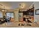Well-lit kitchen with stainless appliances, dark cabinets, mosaic backsplash, granite countertops, and breakfast nook with chandelier at 2533 N 114Th Ave, Avondale, AZ 85392