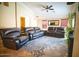 Inviting living room featuring tile floors, ceiling fan, and dark leather furniture at 2533 N 114Th Ave, Avondale, AZ 85392